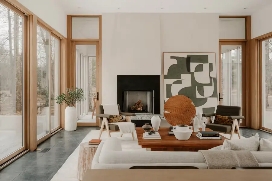 A calm, well-ordered living room with a fireplace and tall windows