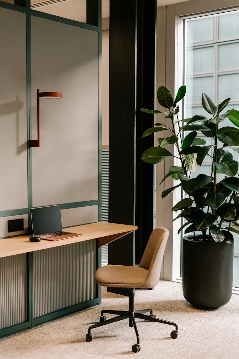Office desk and chair beside a tall window