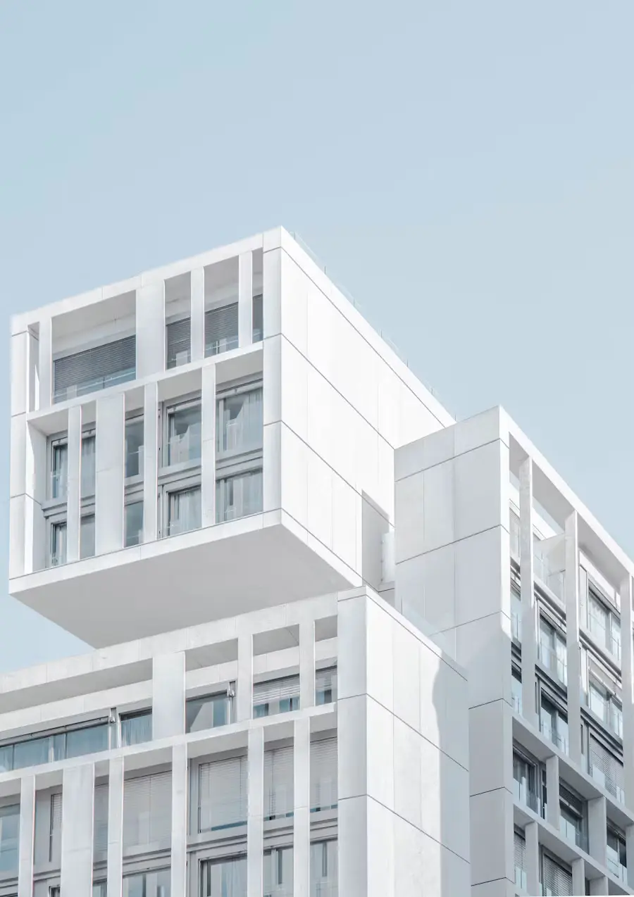 A modern white building against a pale blue sky